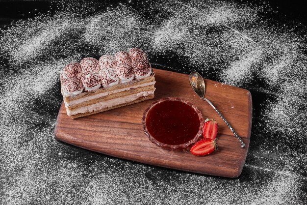 Tiramisu slice on a wooden platter .