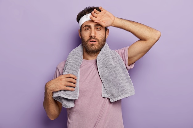 Free photo tired active man posing with sports equipment