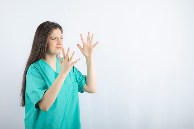 Tired and angry nurse making hand gesture.