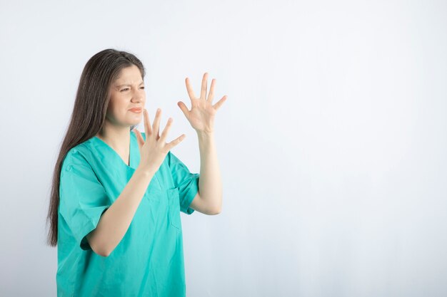手のジェスチャーをする疲れて怒っている看護師。