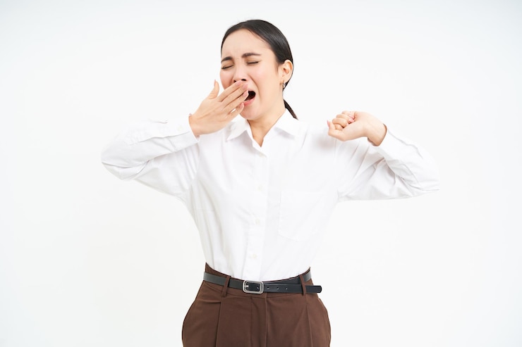 無料Photo 疲れたアジアの企業女性があくびをし、白で隔離された仕事の後、疲労から背中を伸ばす