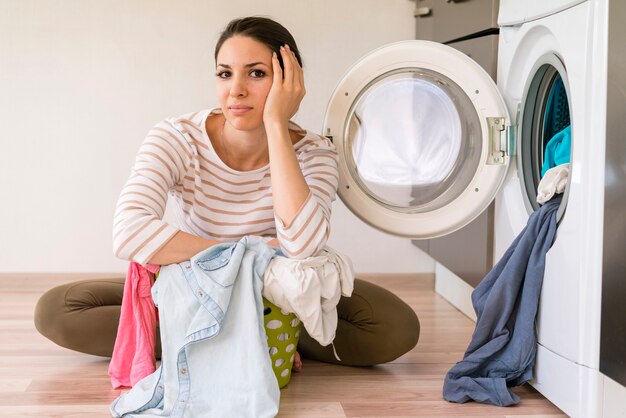 Tired beautiful woman in laundry room