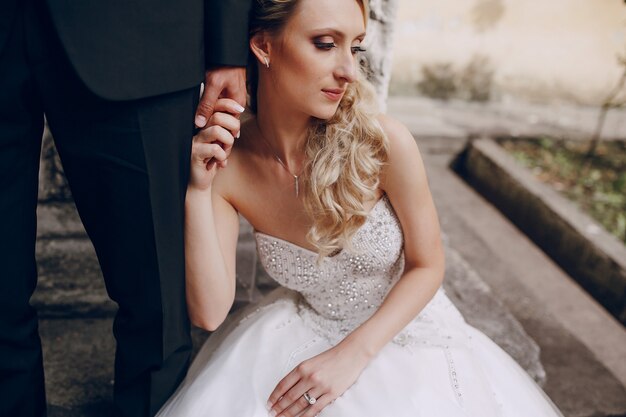 Tired bride holding her husband's hand