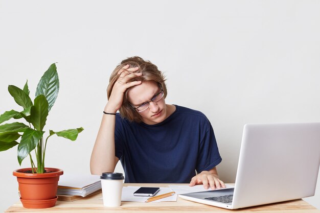 Tired businessman has headache look exasperately into documents, work all day long