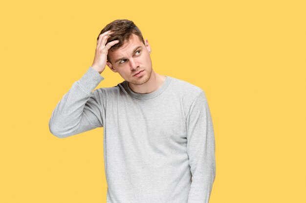 Tired businessman or The serious young man looking at camera over yellow studio