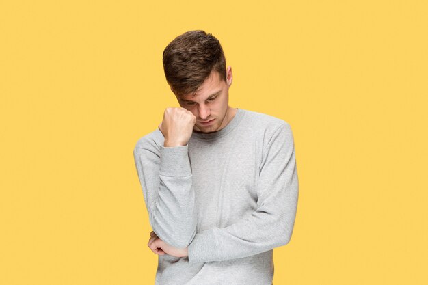 Tired businessman or the serious young man over yellow studio with headache emotions