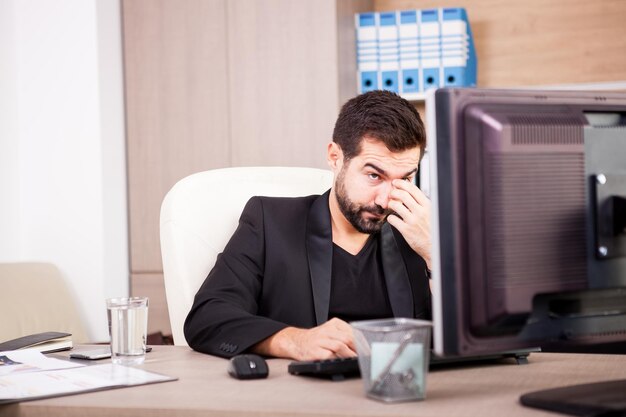 Tired Businessman working in his office. Businessperson in professional environment