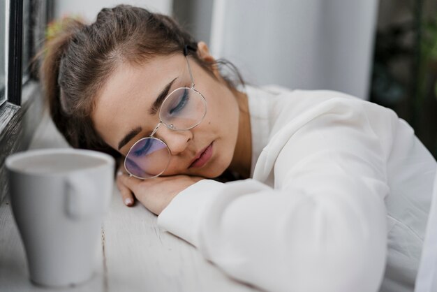 Tired businesswoman resting on a window sill