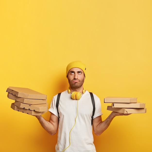 Free photo tired deliveryman with pizza boxes