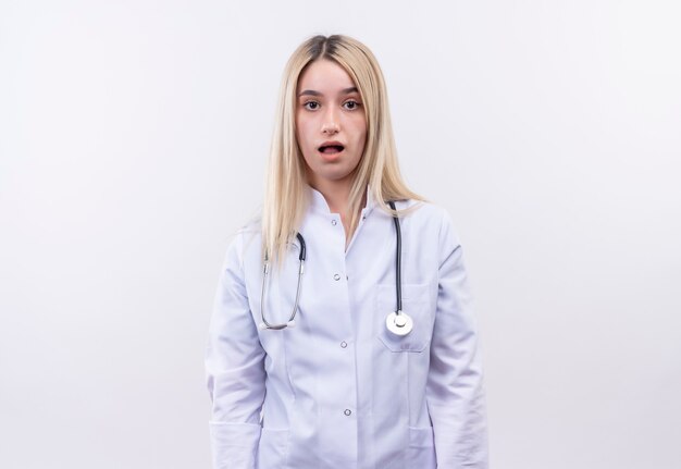  tired doctor young blonde girl wearing stethoscope and medical gown on isolated white wall