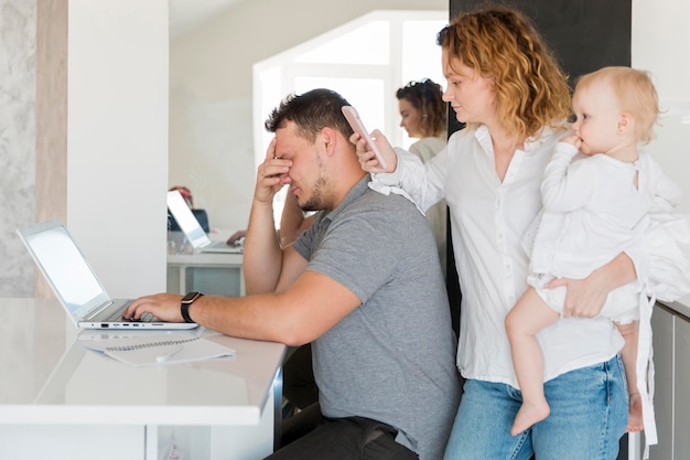 Tired father working on laptop