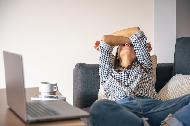 tired from work young woman in front of a laptop