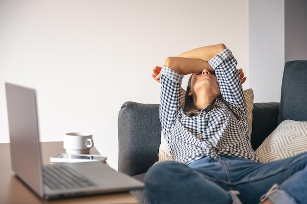 Foto gratuita stanco dal lavoro giovane donna davanti a un computer portatile