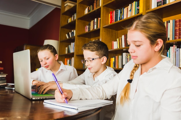 Tired girl doing homework with classmates