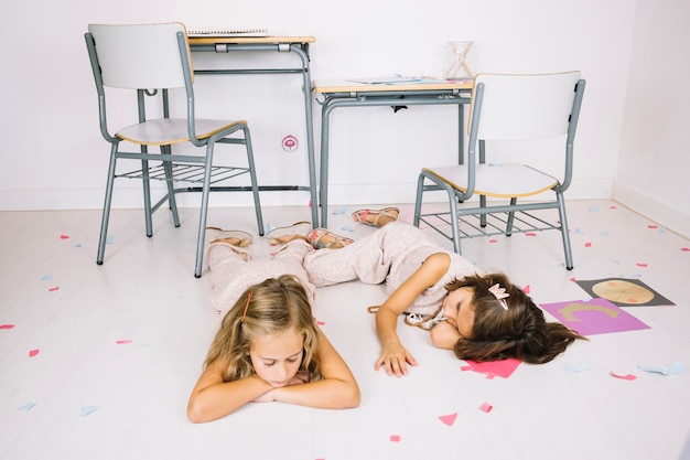 Free photo tired girls sleeping on floor