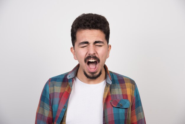 Tired handsome guy yawning