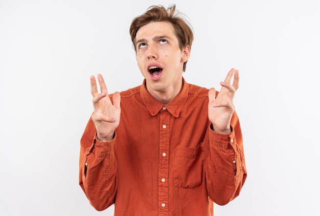 Tired looking up young handsome guy wearing red shirt isolated on white wall