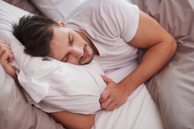 Tired man resting in the bed