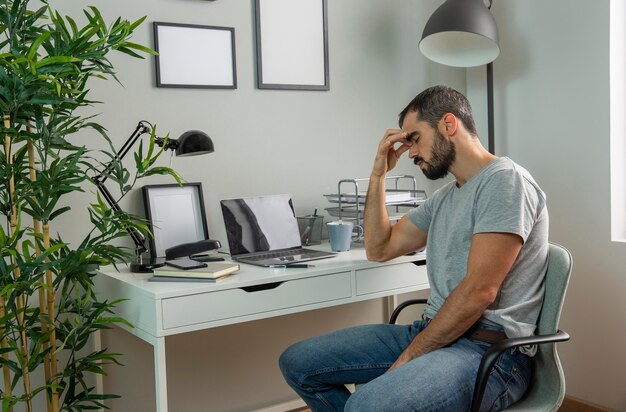 Tired man sitting at his home desk