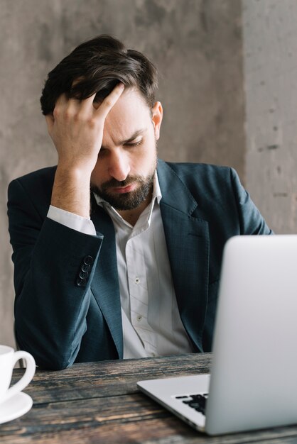 Tired man using laptop