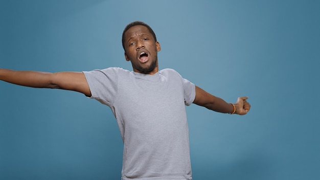 Tired overworked person yawning in front of camera in studio, feeling sleepy and having problem with insomnia. Exhausted depressed man wanting to sleep or take nap, fatigue boredom.