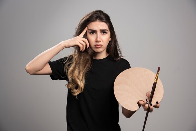 Tired painter holding empty painter palette and brush. 