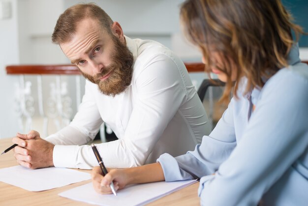 Tired serious businessman looking at camera