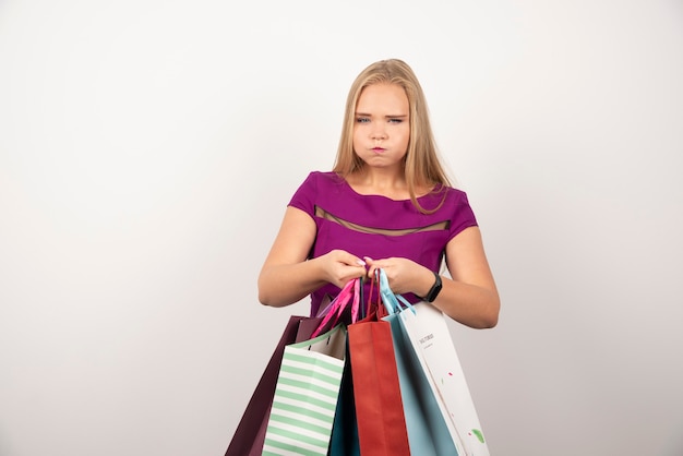 Tired shopaholic holding colorful shopping bags.