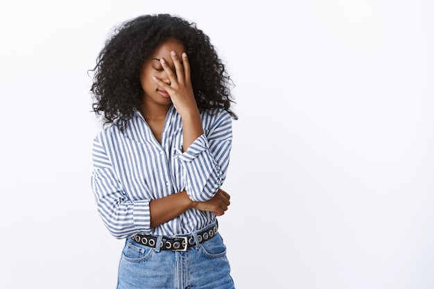 Free photo tired snobbish good-looking stylish african american curly-haired woman facepalm close eyes bothered dumb stupid coworker made mistake standing exhausted pissed annoyed, wanna go home