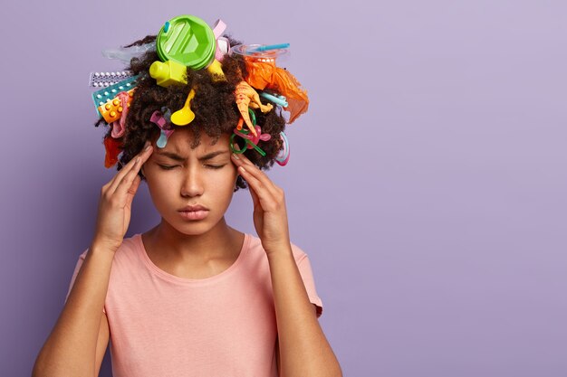 Tired stressful woman posing with garbage in her hair