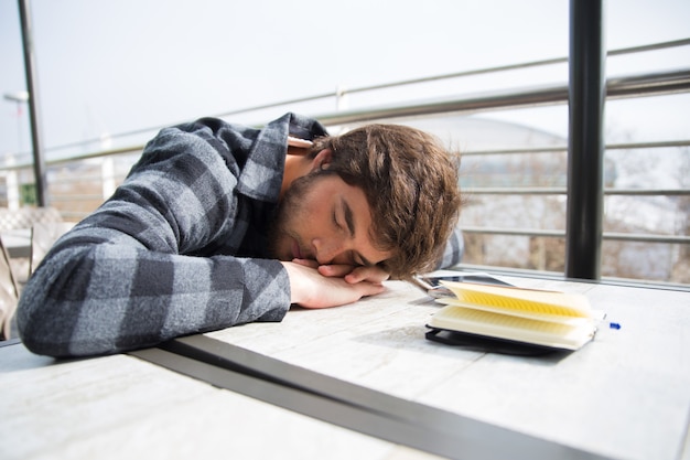 Free photo tired student sleeping with his head rested on table