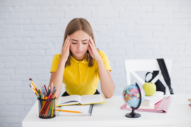 Tired teenager holding her head