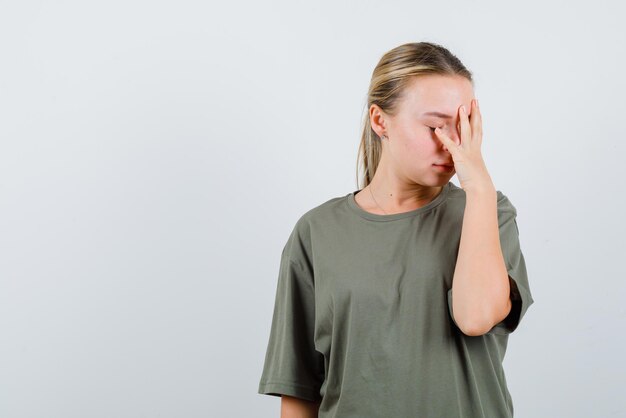 The tired woman is putting her hand on face on white background