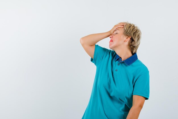 The tired woman is putting her hand on forehead on white background