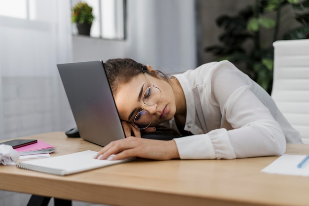 Free photo tired woman resting her head on a laptop