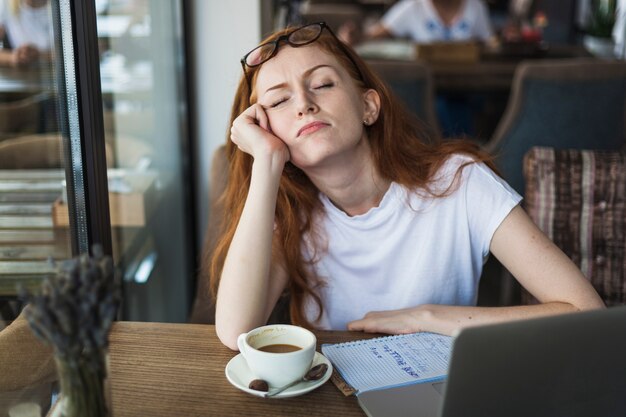 Tired woman sitting at table