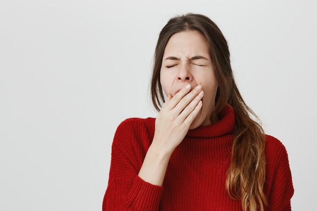 Tired woman yawning, cover opened mouth