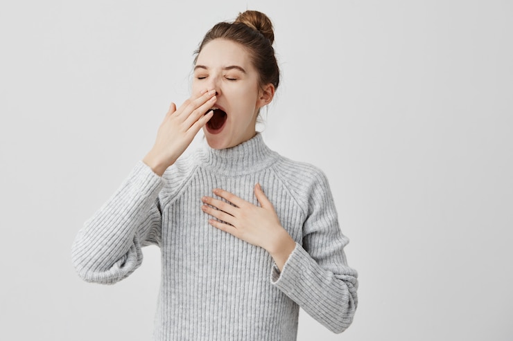 Free Photo tired woman yawning covering open mouth with hand need rest. young female worker being sleepy head can't wake up having insomnia. chain reaction
