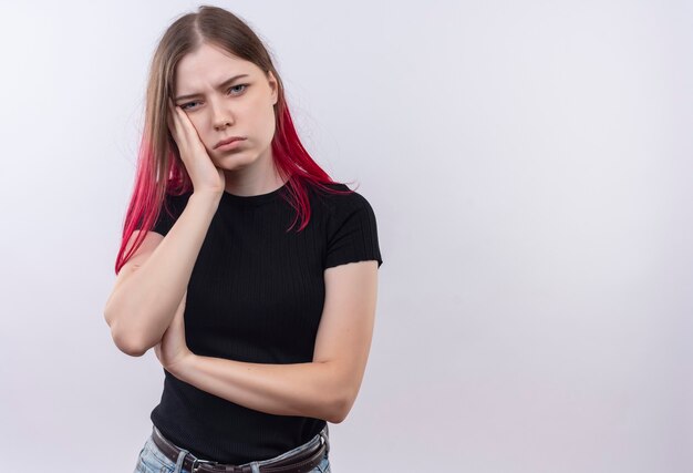 Tired young beautiful girl wearing black t-shirt putting her hand on cheek on isolated white wall with copy space