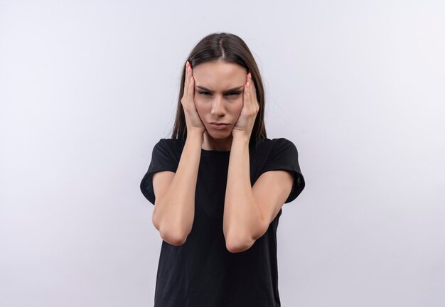 Tired young caucasian girl wearing black t-shirt put her hands on cheek on isolated white