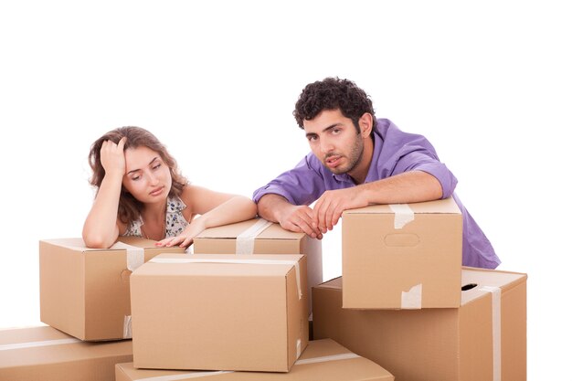 Tired young couple with cardboard boxes