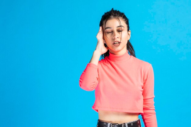 Tired young girl holding her hand to her head and closed her eyes High quality photo