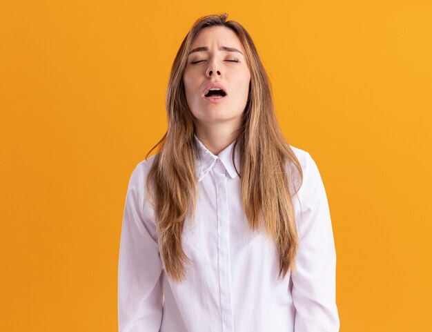 Tired young pretty caucasian girl stands with closed eyes