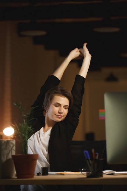 Tired young woman designer sitting in office