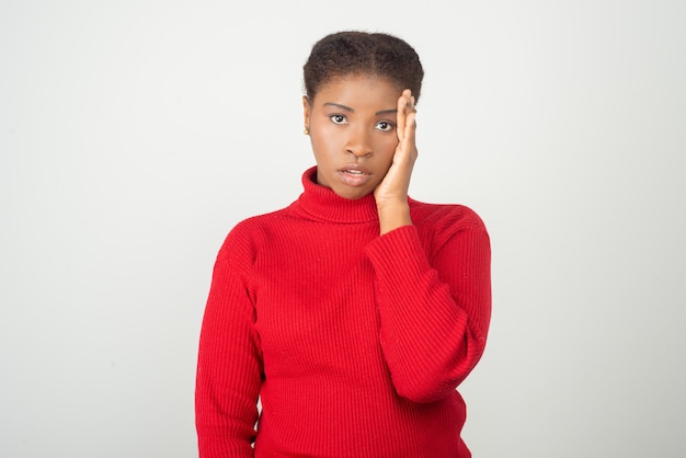 Tired young woman holding hand on head