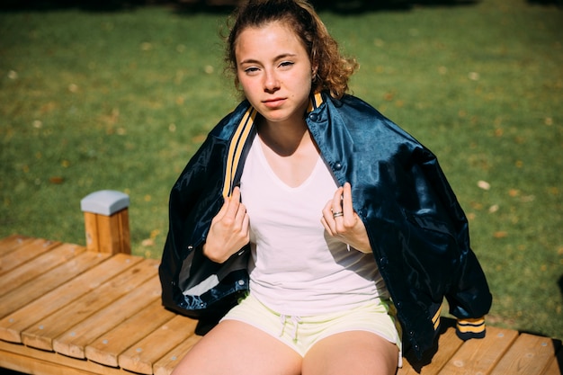 Tired young woman resting at sportsground