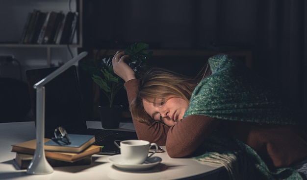 Foto gratuita la giovane donna stanca sul posto di lavoro vuole dormire fino a tardi la notte