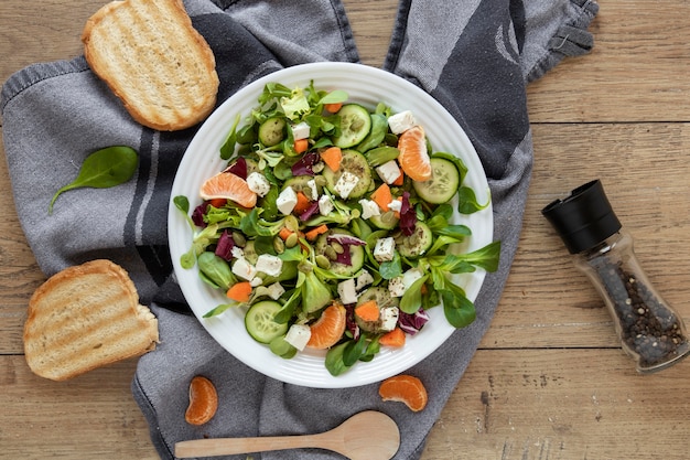 Toast bread beside plate with salad on table