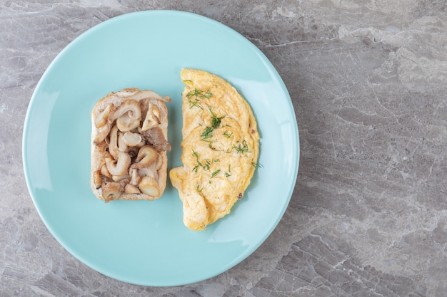 Toast bread and omelette on blue plate.