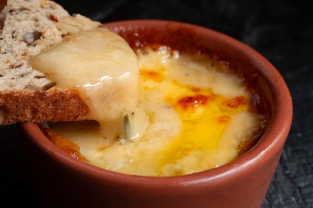 Toast dipped in melted cheese bowl